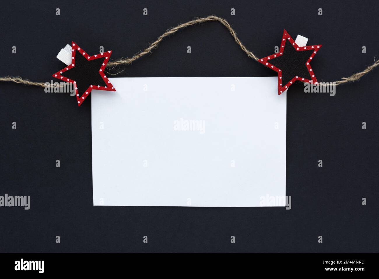 Maquette. Feuille blanche de bloc-notes sur fond noir. Une feuille sur des épingles à linge et une corde. Minimalisme conceptuel des affaires. Le concept de la publicité, Banque D'Images