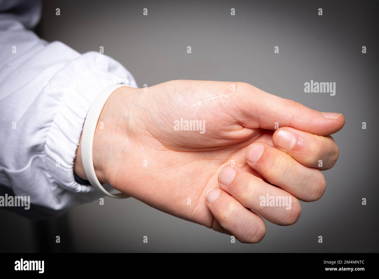 Gros plan d'une main et d'un poignet d'un homme caucasien isolé sur fond gris. Concept de tunnel carpien et douleur articulaire due à l'inflammation des tendons Banque D'Images