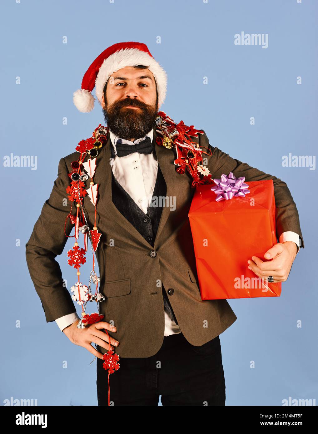 Le Manager avec la barbe tient le cadeau rouge. Homme en costume élégant Banque D'Images