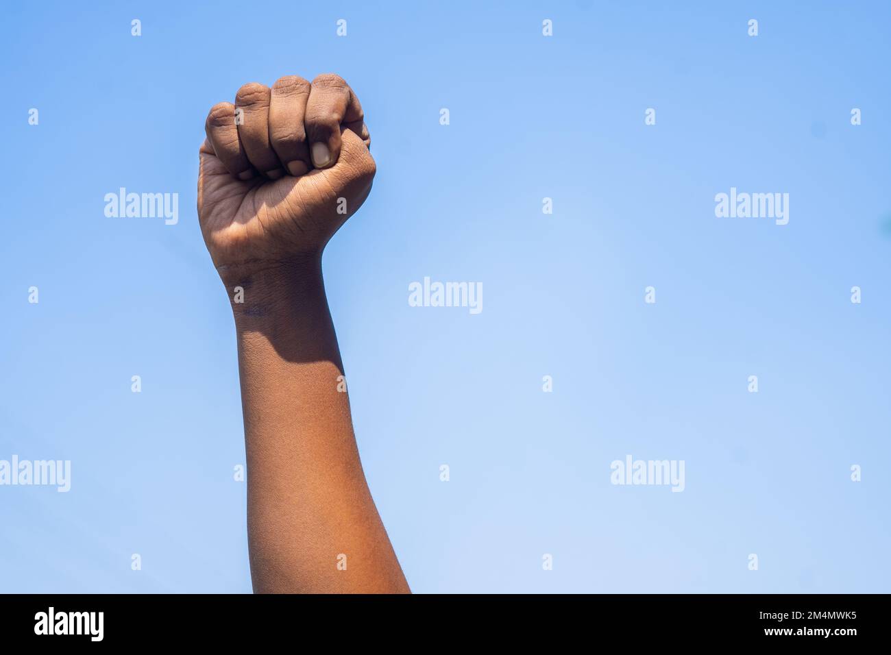 Concept de célébration du mois de l'histoire des Noirs ou main activiste se levant contre le ciel pendant le mois de mars montrant avec l'espace de copie Banque D'Images