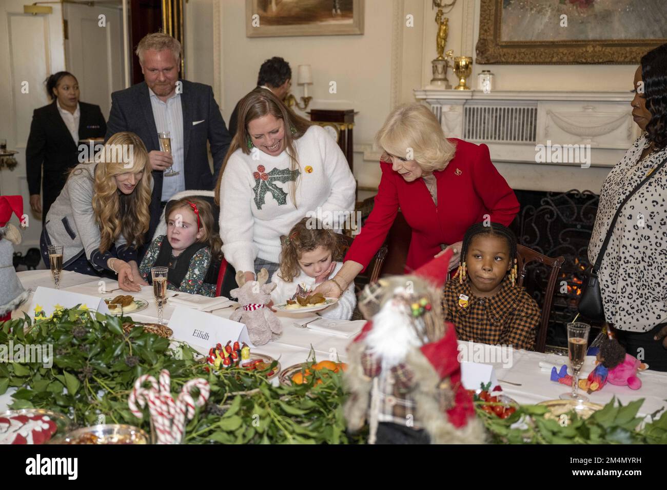 Photo du dossier datée du 07/12/22 de la Reine Consort, servant de la nourriture à Eilidh Currie (centre) pendant un événement à Clarence House à Londres. Eilidh, cinq ans, et son frère Cameron, trois ans, ont vu des rennes, ont aidé à décorer l'arbre et ont rencontré le Père Noël lors de leur visite à Clarence House. Date de publication : jeudi 22 décembre 2022. Banque D'Images