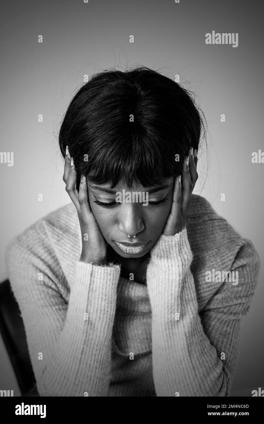 Jeune afro-américaine aux problèmes de dépression - traitement des troubles émotionnels et de l'humeur - montage noir et blanc Banque D'Images