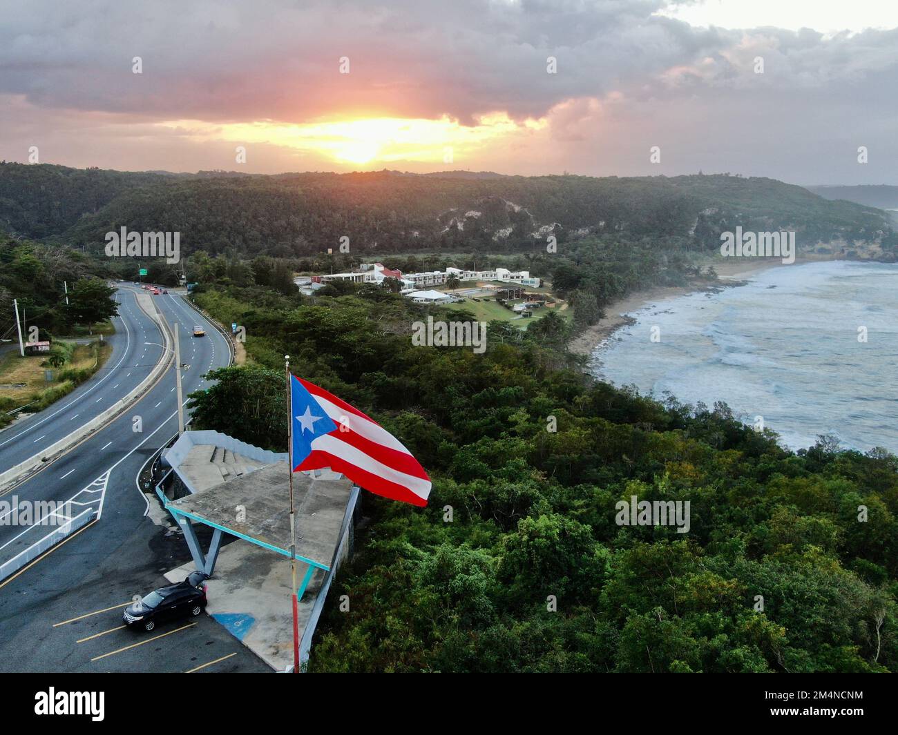 Une photo aérienne du drapeau de Porto Rico qui agite dans l'air à un coucher de soleil doré à Quebradillas Banque D'Images