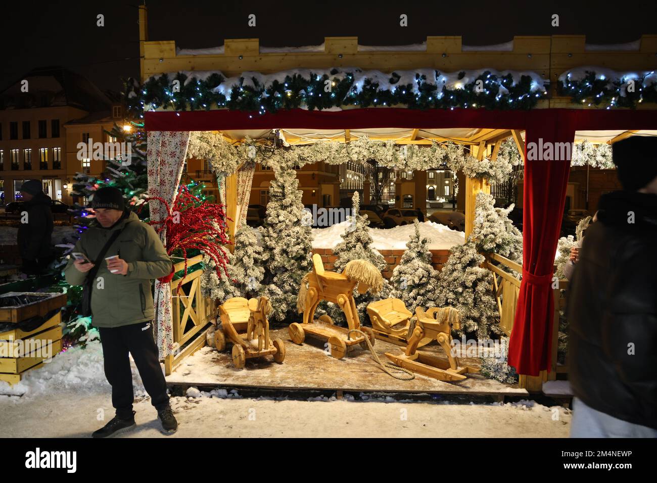 Stalle avec des chevaux jouets en bois (traîneau et chevaux jouets de traction) et des arbres de noël sur un marché de Noël à Varsovie, Pologne Banque D'Images