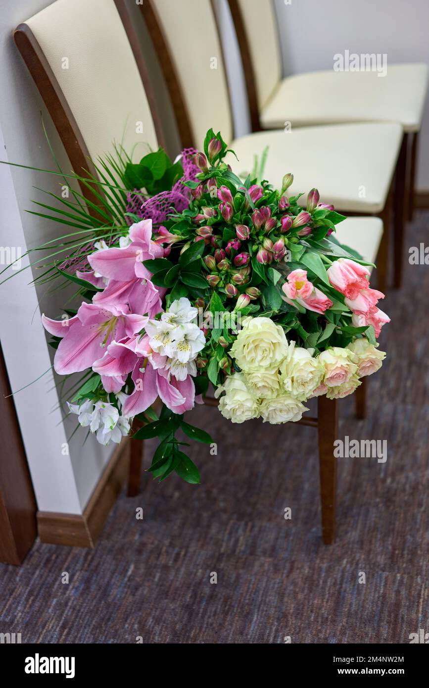 Grand bouquet de fleurs colorées sur un fauteuil blanc. Jour de mariage. Banque D'Images
