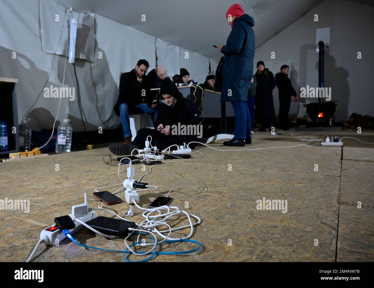 Kiev, Ukraine. 22nd décembre 2022. Les gens chargent leurs téléphones mobiles au poste de police mobile lors d'une panne de courant à Kiev. L'armée russe a mené des attaques massives de roquettes et de drones kamikaze sur les infrastructures énergétiques ukrainiennes. Après de graves dommages au réseau électrique dans de nombreuses villes d'Ukraine, la compagnie nationale d'électricité Ukrenergo a introduit des coupures d'électricité d'urgence et toutes les heures. (Credit image: © Sergei Chuzavkov/SOPA Images via ZUMA Press Wire) Banque D'Images