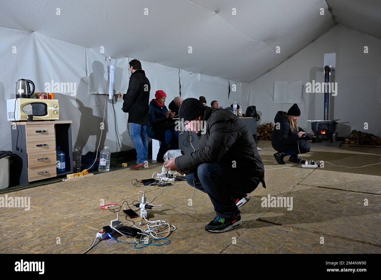 Kiev, Ukraine. 22nd décembre 2022. Les gens chargent leurs téléphones mobiles au poste de police mobile lors d'une panne de courant à Kiev. L'armée russe a mené des attaques massives de roquettes et de drones kamikaze sur les infrastructures énergétiques ukrainiennes. Après de graves dommages au réseau électrique dans de nombreuses villes d'Ukraine, la compagnie nationale d'électricité Ukrenergo a introduit des coupures d'électricité d'urgence et toutes les heures. (Credit image: © Sergei Chuzavkov/SOPA Images via ZUMA Press Wire) Banque D'Images