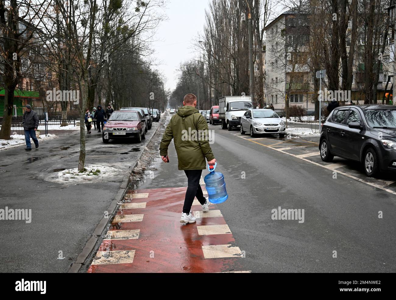 Kiev, Ukraine. 22nd décembre 2022. Un homme porte une bouteille d'eau en plastique lors d'une panne de courant à Kiev. L'armée russe a mené des attaques massives de roquettes et de drones kamikaze sur les infrastructures énergétiques ukrainiennes. Après de graves dommages au réseau électrique dans de nombreuses villes d'Ukraine, la compagnie nationale d'électricité Ukrenergo a introduit des coupures d'électricité d'urgence et toutes les heures. (Credit image: © Sergei Chuzavkov/SOPA Images via ZUMA Press Wire) Banque D'Images