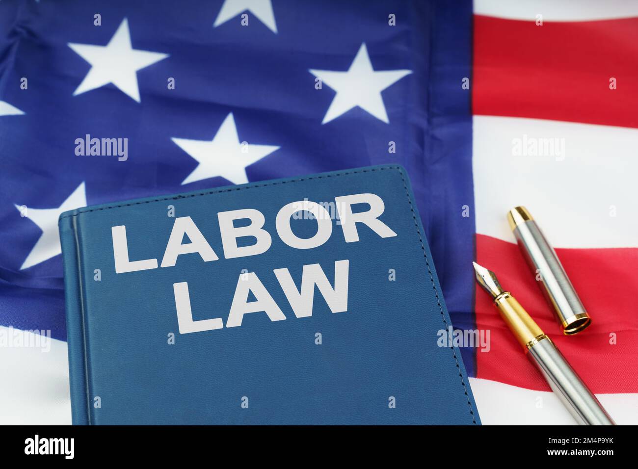 Concept de droit. Sur le drapeau américain se trouve un stylo et un livre  avec l'inscription - DROIT DU TRAVAIL Photo Stock - Alamy