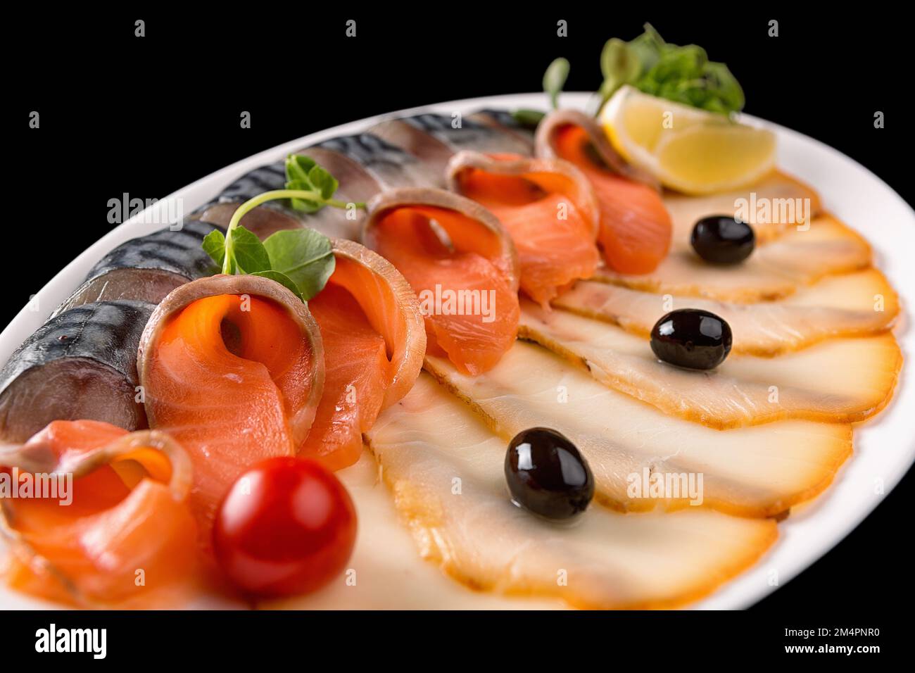 Assortiment de poissons avec citron, olives et tomates cerises, gros plan Banque D'Images