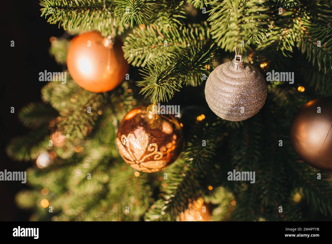 Fermez les boules sur l'arbre de Noël. Guirlande de bokeh en arrière-plan. Le concept de la nouvelle année. Banque D'Images