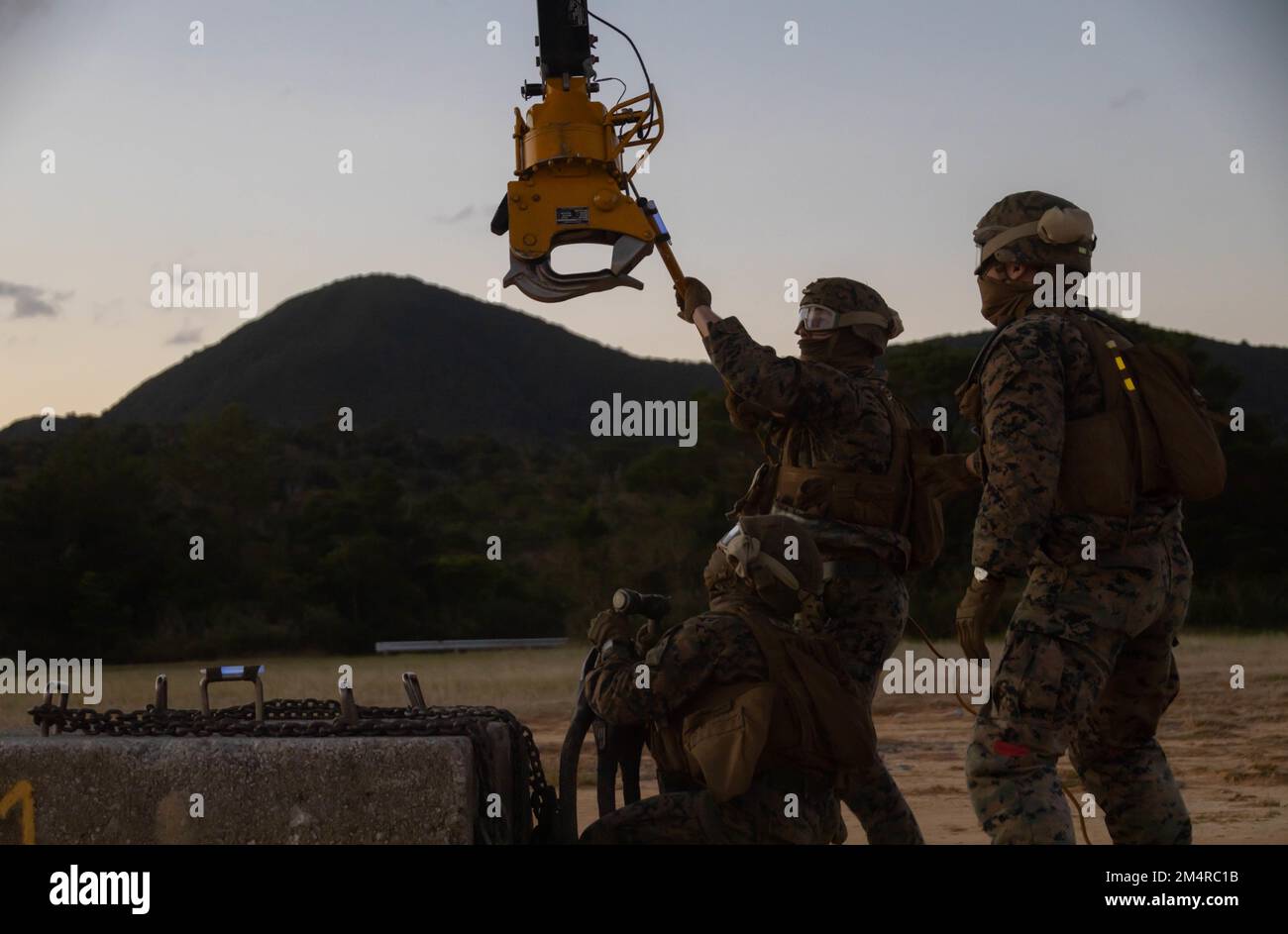 ÉTATS-UNIS Corps de la marine Cpl Riley Wharton, à gauche, Cpl James Hite, au milieu, Et le caporal John Oldland, à droite, tous les spécialistes de soutien à l'atterrissage du bataillon de logistique de combat 31, 31st Marine Expeditionary Unit, accrochent la cargaison à l'élingue d'un Super Stallion CH-53E lors d'un exercice d'équipe de soutien à l'hélicoptère au Camp Hansen, Okinawa, 20 décembre 2022. L’exercice de la TVH était un test effectué pour certifier des pilotes dans des opérations de chargement de harnais et pour accroître la compétence de spécialité d’occupation militaire de la NCB 31 Marines. Le MEU de 31st, le seul MEU en permanence déployé par le corps des Marines, offre une flexibilité et une létalité Banque D'Images