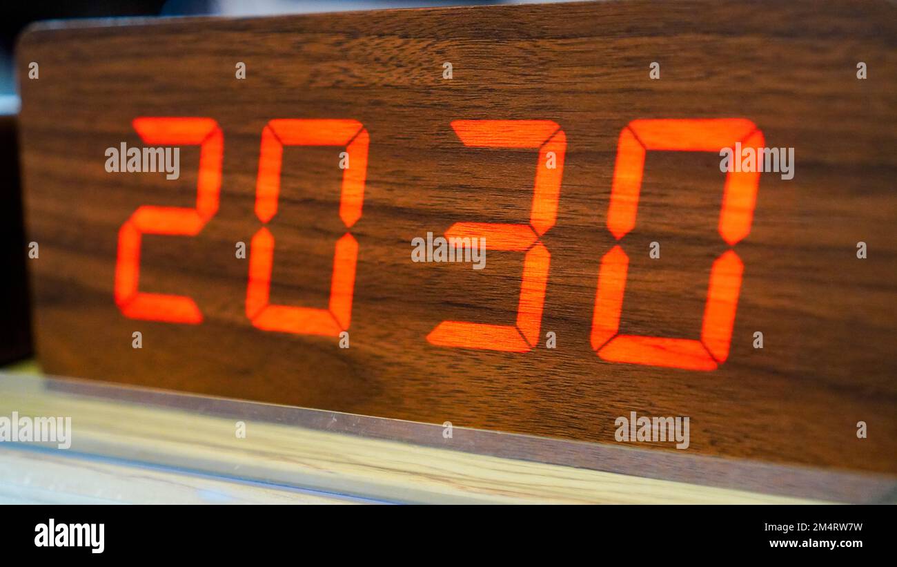 Horloge numérique en bois et LED rouge qui montre l'heure 20:30 Banque D'Images