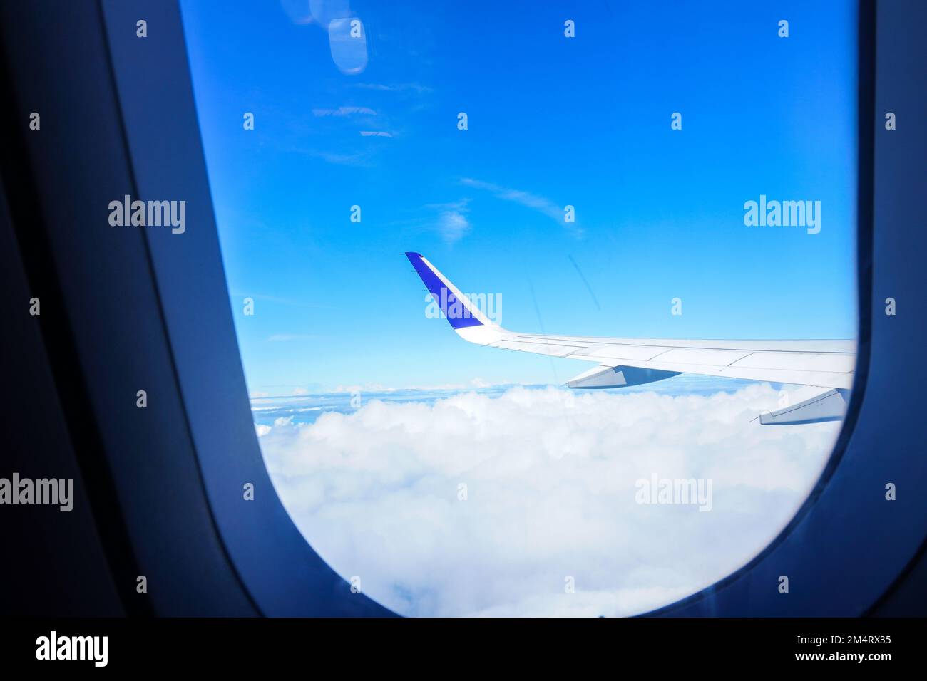 Vue des ailes de l'avion de la fenêtre contre le ciel bleu et nuageux. Vue depuis la fenêtre de l'avion Banque D'Images
