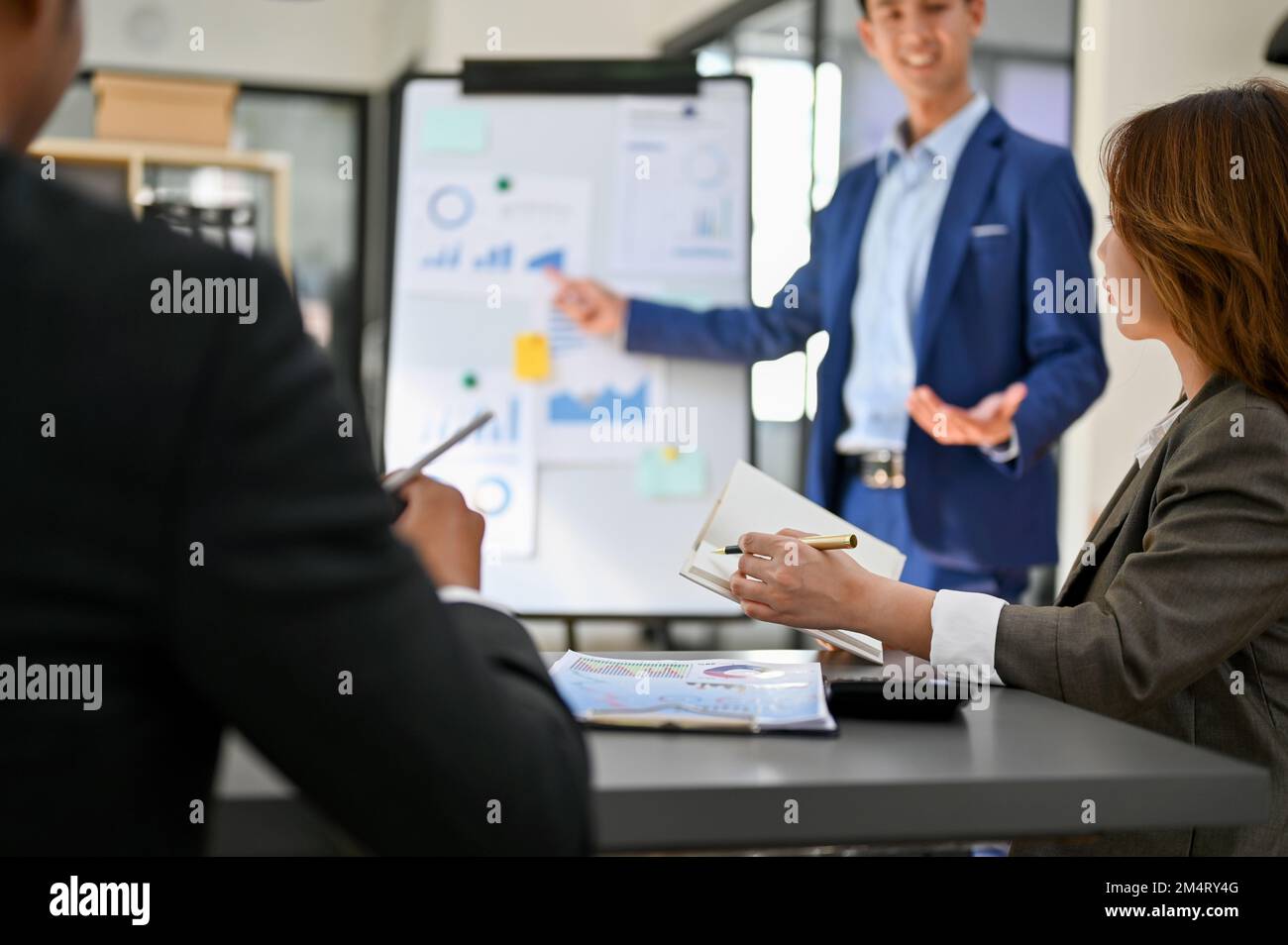 Les membres du conseil d'administration sont à la réunion tandis qu'un homme d'affaires asiatique professionnel et intelligent du millénaire pitching ou de présenter sa nouvelle strat d'investissement financier Banque D'Images