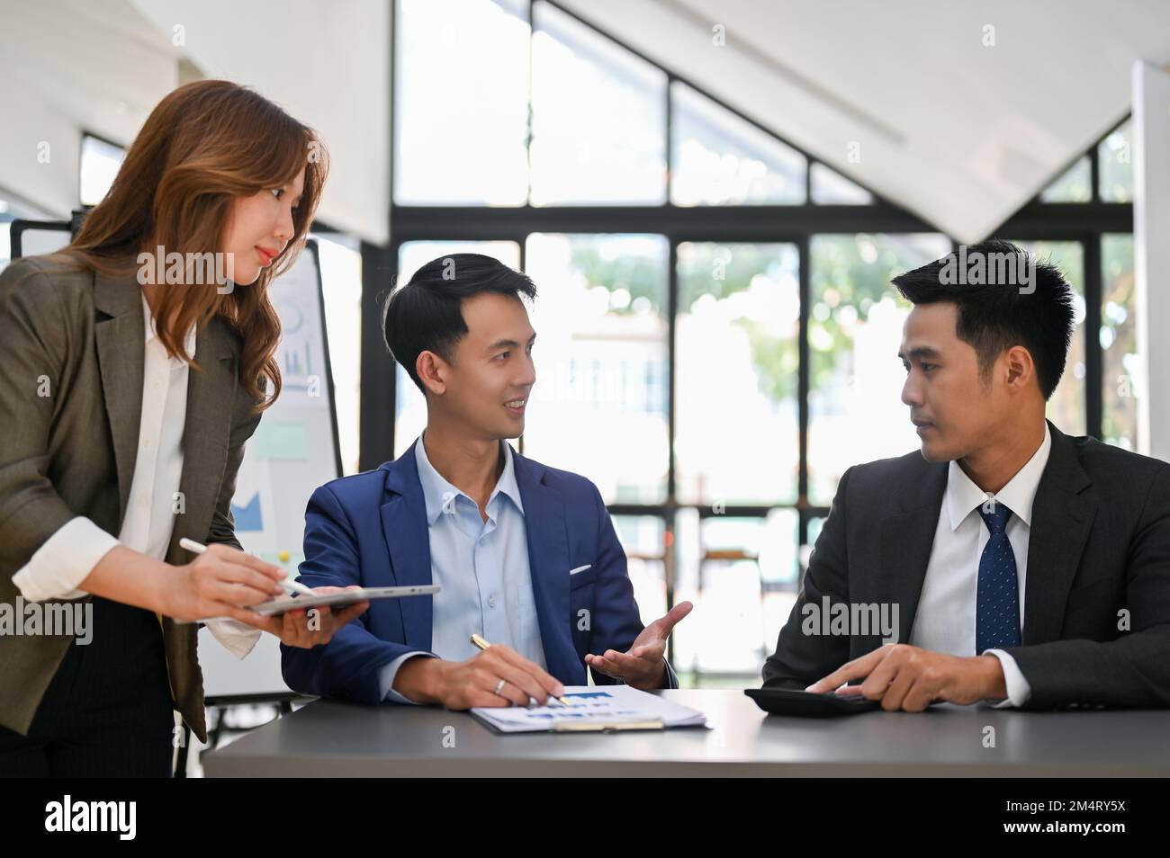 Homme d'affaires asiatique ciblé et intelligent ayant une conversation d'affaires avec son partenaire d'affaires lors de la réunion. Banque D'Images