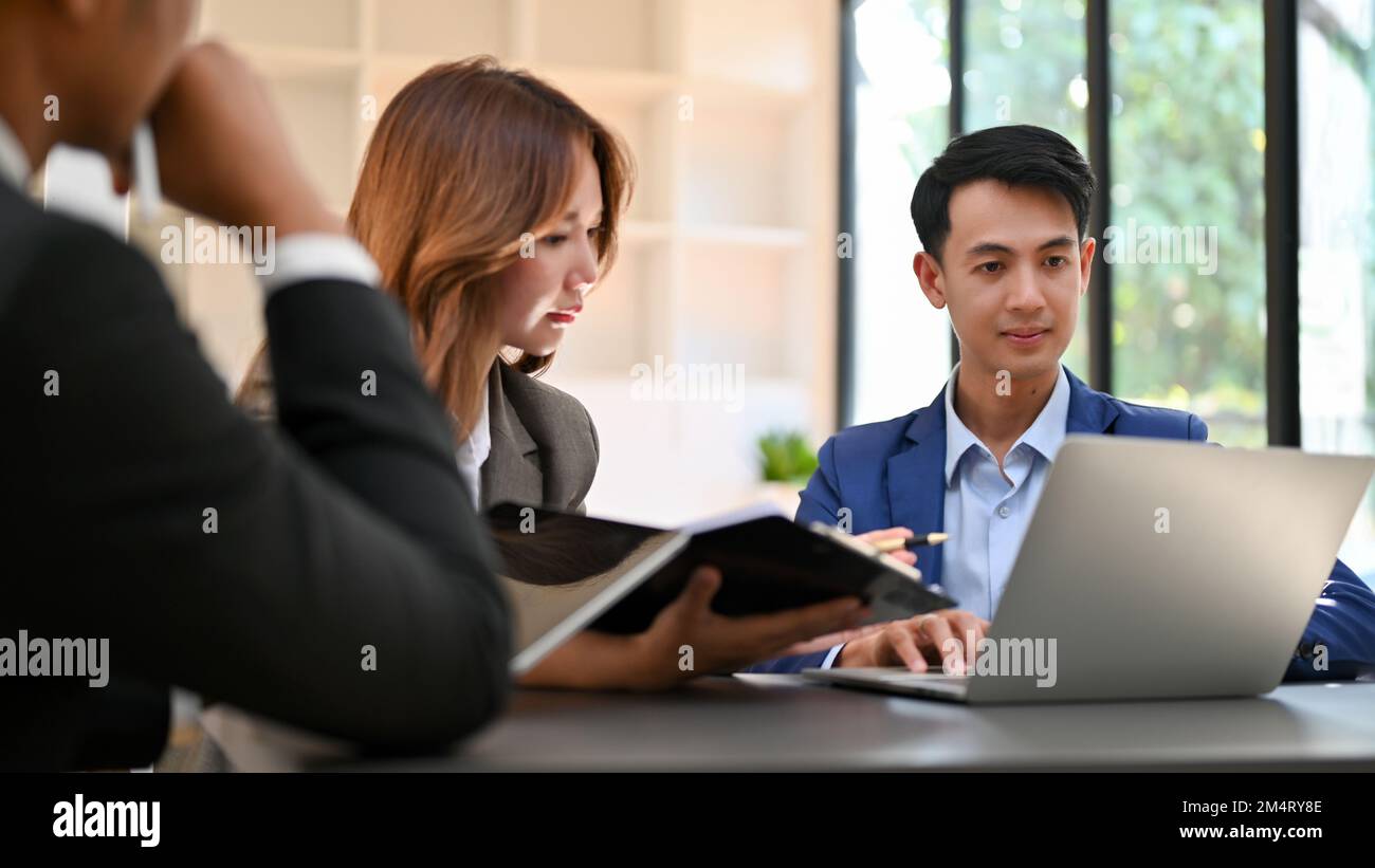 Groupe d'hommes d'affaires asiatiques ayant une réunion formelle, brainstorming et planification d'une nouvelle stratégie de marketing pour un nouveau produit. Banque D'Images