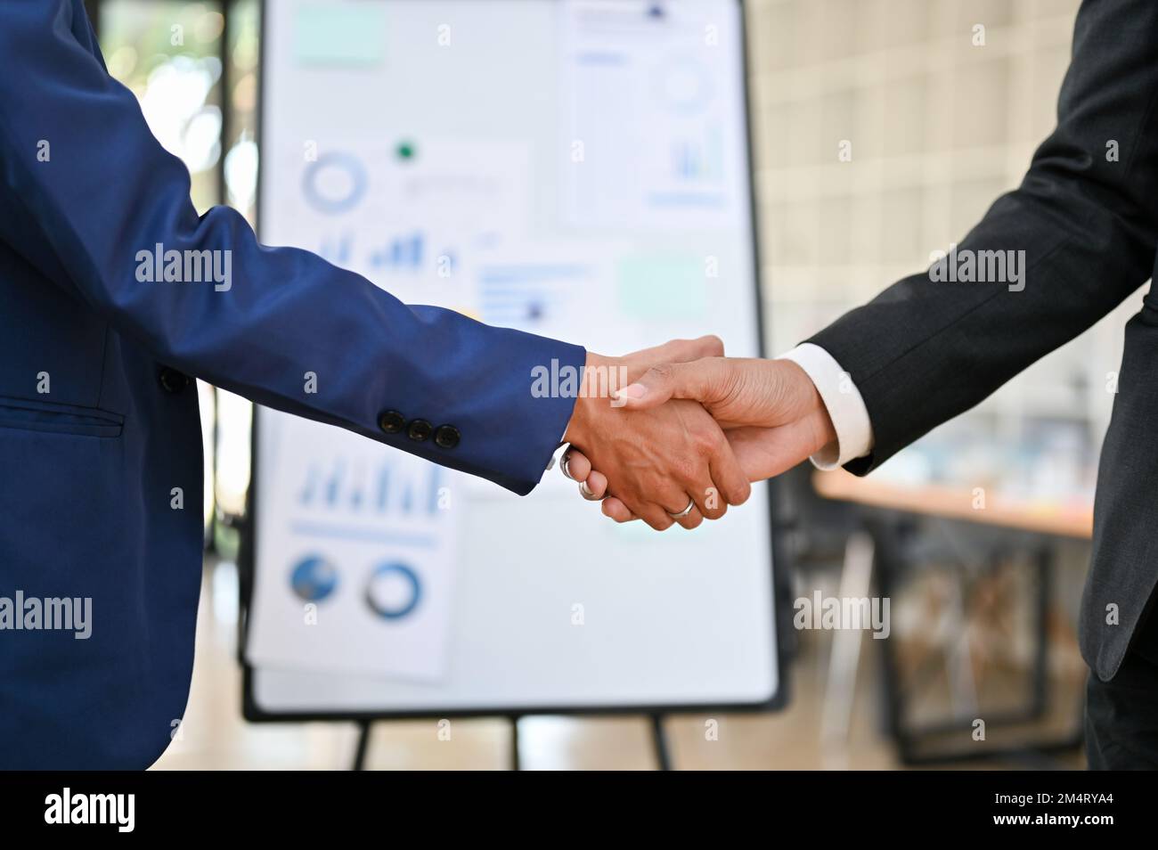 Gros plan, deux hommes d'affaires se secouant la main après une réunion d'entreprise. réussite, partenariat, bienvenue, félicitations, affaires commerciales. Banque D'Images