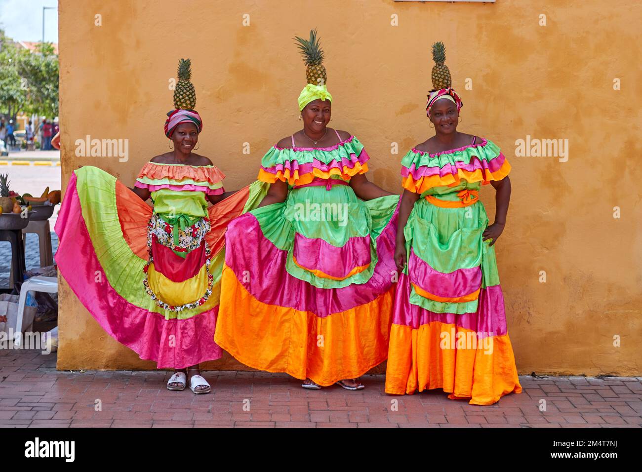 Une image de Palenceras avec des tissus lumineux et des ananas sur leur tête à Cartagena, Colombie Banque D'Images