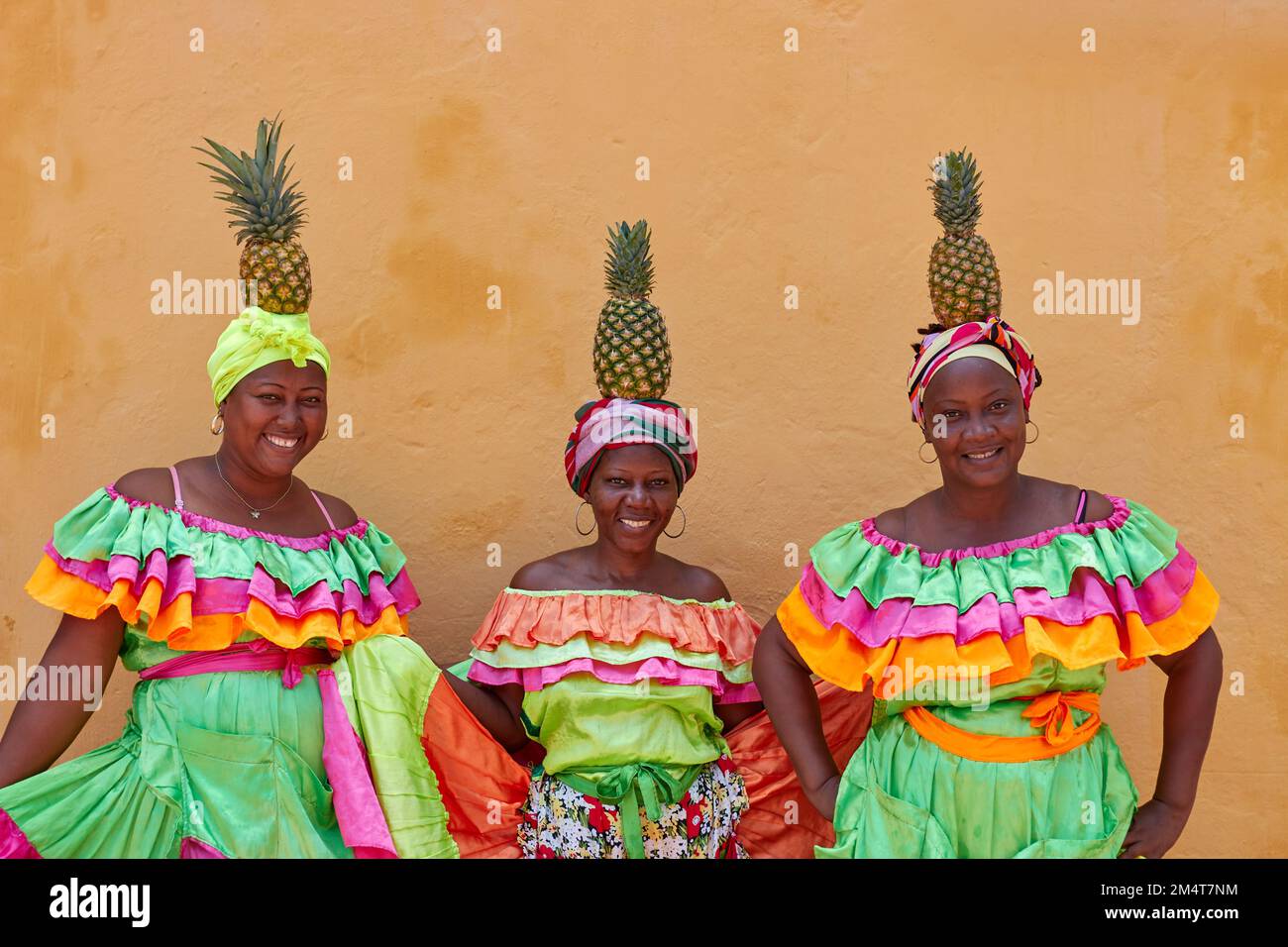 Une image de Palenceras avec des tissus lumineux et des ananas sur leur tête à Cartagena, Colombie Banque D'Images