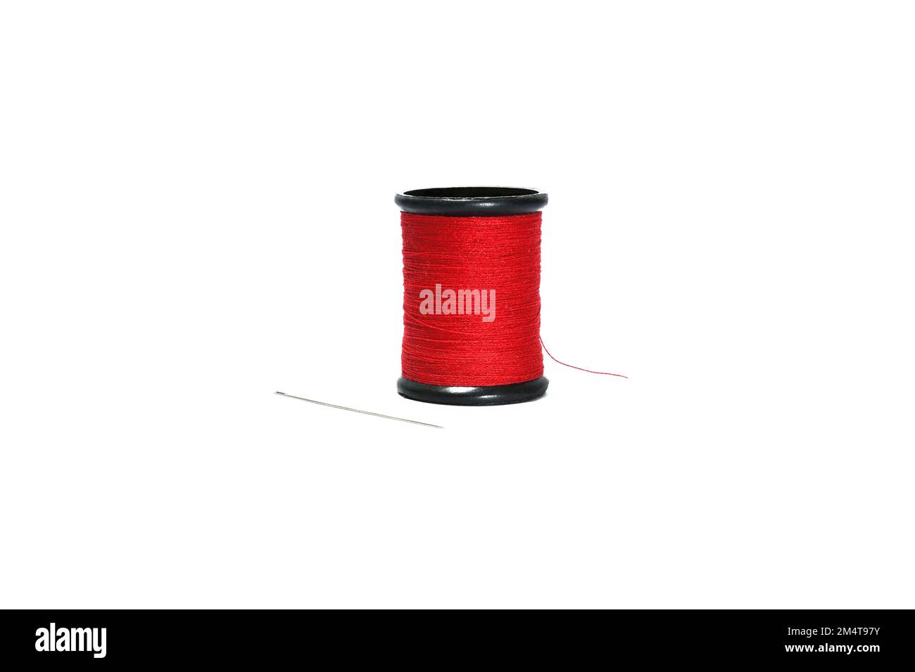 Fil à coudre rouge en rouleau noir avec aiguille à coudre isolée sur fond blanc. Banque D'Images