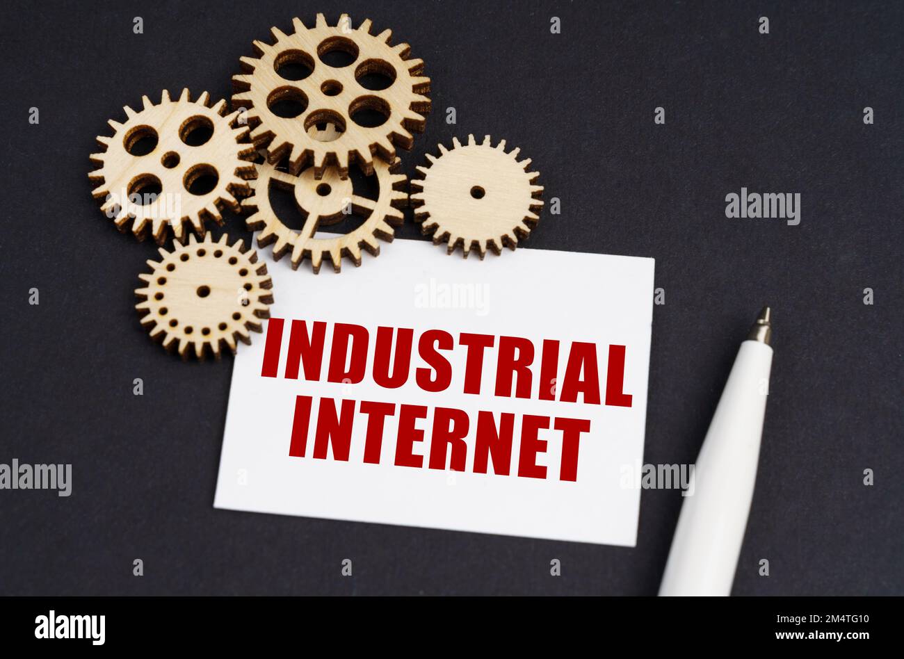 Concept industriel. Sur la surface noire se trouvent des engrenages, un stylo et une carte de visite avec l'inscription - Industrial Internet Banque D'Images