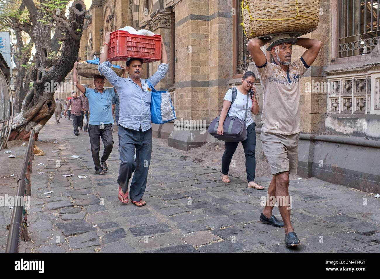 Porteurs avec des paniers de poissons sur leur tête, à Chhatrapati Shivaji Maharaj Terminus (CMST), à Mumbai, Inde, pour faire avancer les paniers par train Banque D'Images