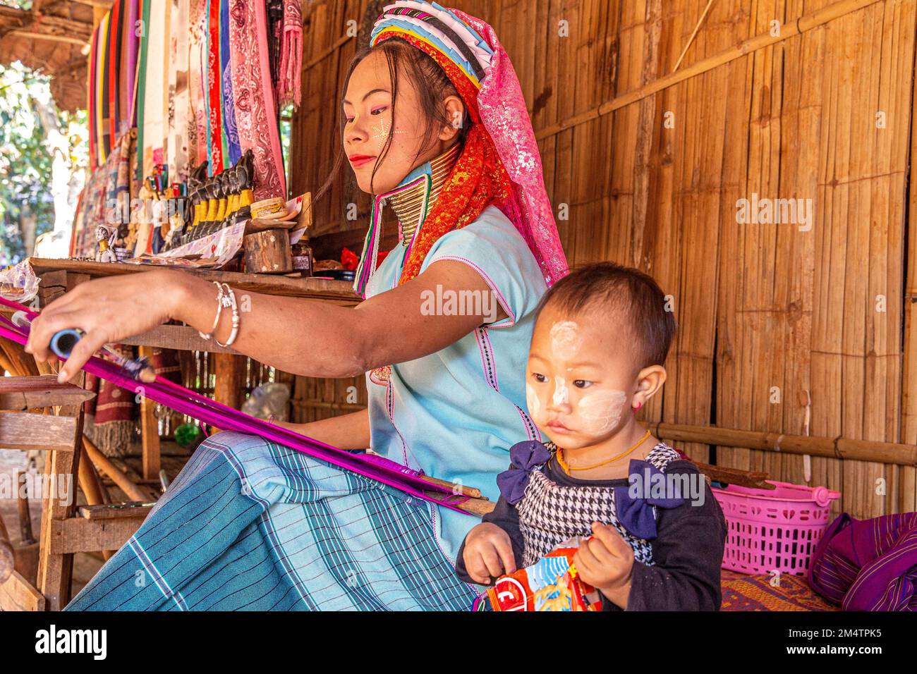 (221223) -- CHIANG RAI, le 23 décembre 2022 (Xinhua) -- Une femme déchaîne des tissus dans un village Karen de Chiang Rai, Thaïlande, le 22 décembre 2022. Le peuple Karen, qui vit dans le nord-ouest de la Thaïlande, considère les longs cols comme de la beauté. Les filles locales commencent à porter des colliers en cuivre à l'âge de 4 ou 5 ans. Avec le changement de temps, le nombre de femmes portant des colliers a considérablement diminué, et la coutume de long cou est progressivement entrée dans l'histoire. (Xinhua/Wang Teng) Banque D'Images