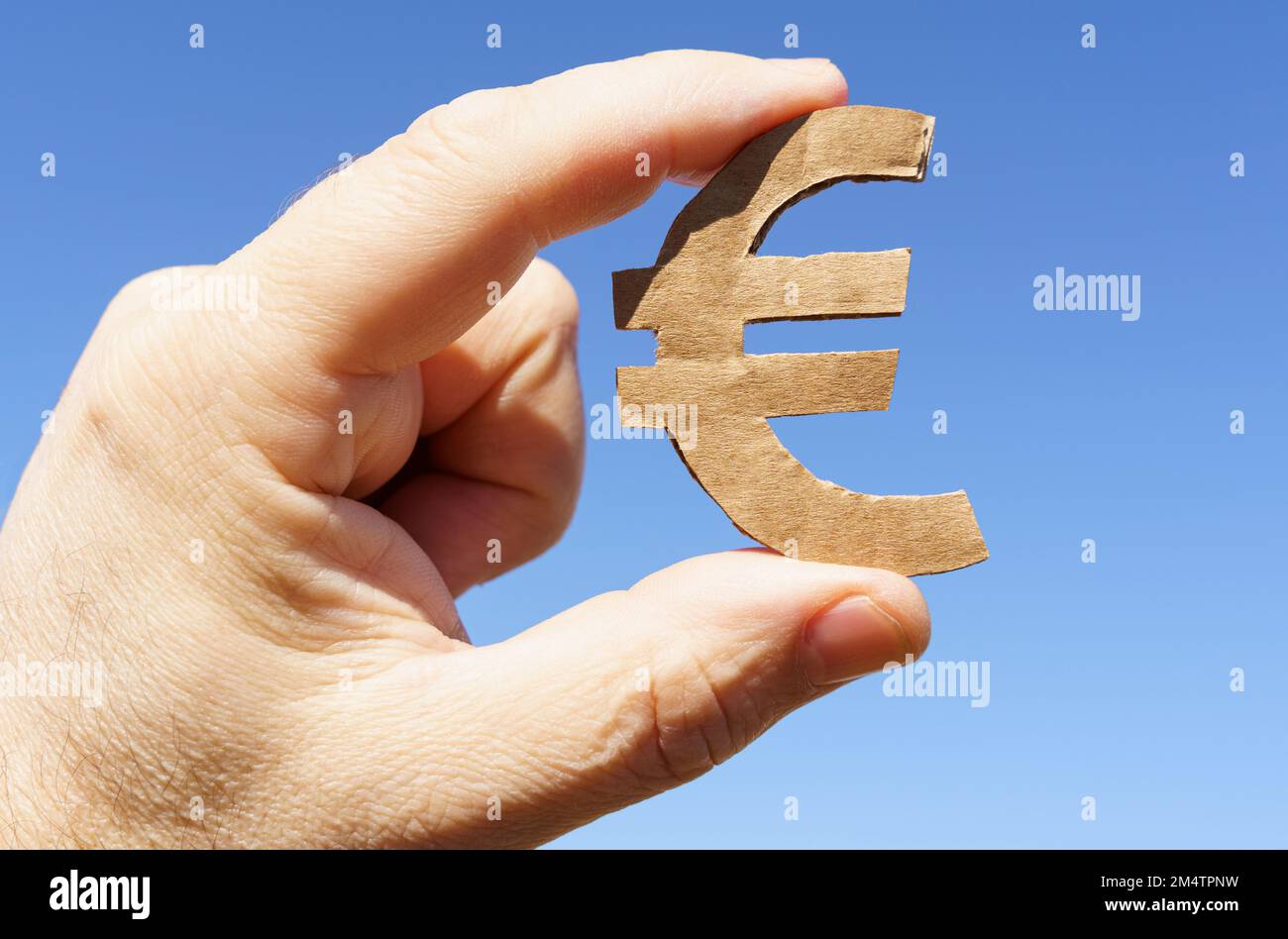 Symboles monétaires. Sur fond de ciel entre les mains d'un homme le symbole de l'euro Banque D'Images