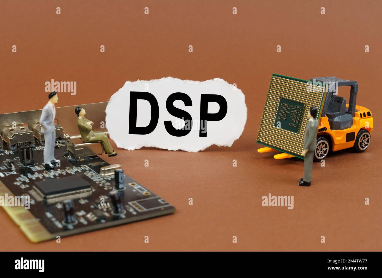 Concept de technologie et d'entreprise. Sur une surface marron, un chargeur avec un processeur, un microcircuit, des figures de personnes et du papier déchiré avec l'inscription Banque D'Images