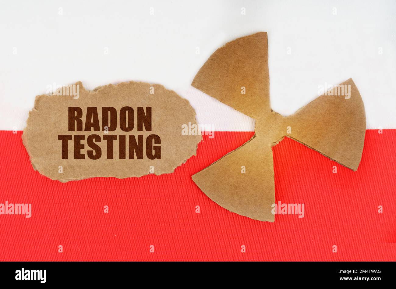 Le concept de l'industrie et de la radiation. Sur le drapeau de la Pologne, le symbole de radioactivité et de carton déchiré avec l'inscription - radon Testing Banque D'Images