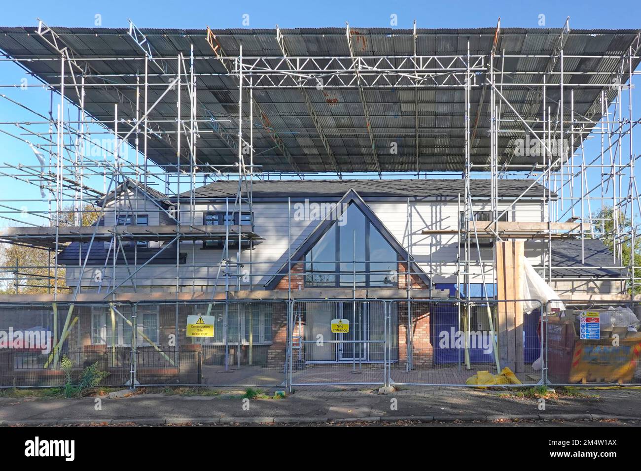 Construction de bâtiments transformation de bungalow pour la maison verticale de feuilles de plastique enlevé toit ondulé sur l'échafaudage cadre de poutre d'échelle reste Royaume-Uni Banque D'Images