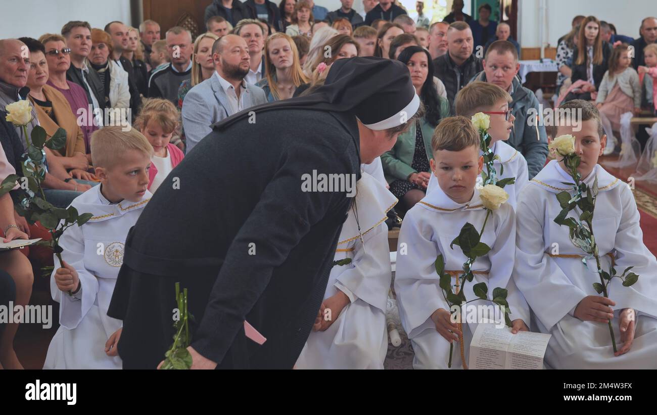 Pervomaysk, Bélarus - 17 juin 2022 : les enfants dans l'église à leur première communion catholique. Banque D'Images