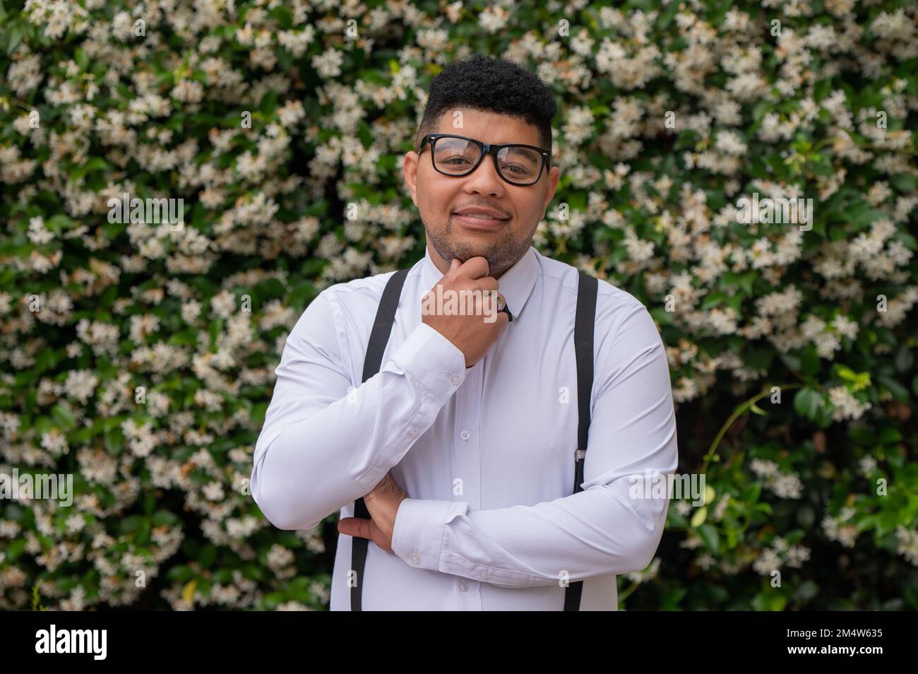 Jeune homme debout devant les plantes Banque D'Images