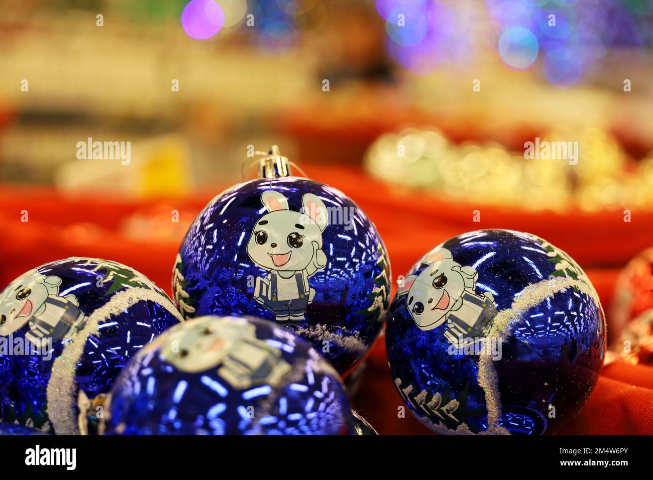 Jouets de Noël, boules bleues avec lapin - symbole du nouvel an chinois 2023 sur fond de lumières festives floues. Décorations du nouvel an dans un magasin Banque D'Images