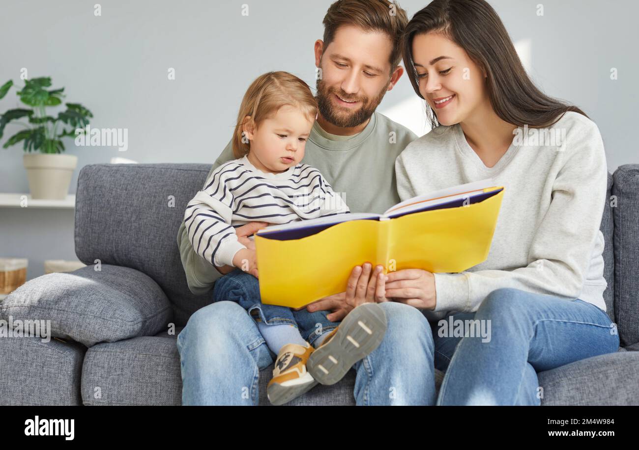 Portrait des parents et de leur adorable tout-petit bébé assis sur un canapé Banque D'Images