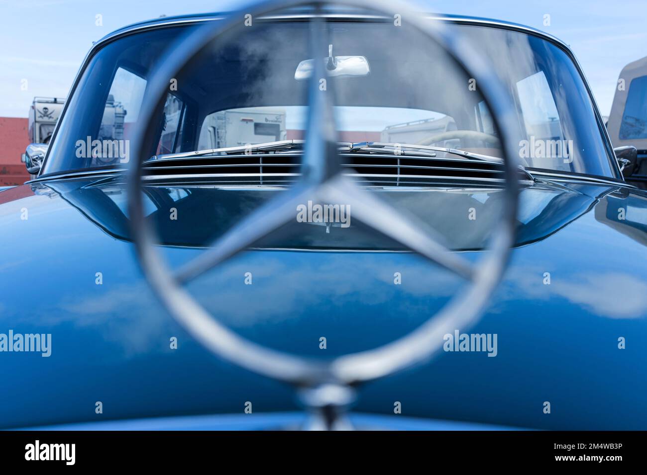 Emblème Mercedes Benz sur le capot d'une voiture bleue Banque D'Images