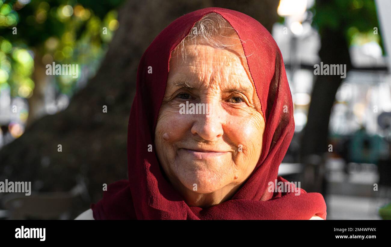 Portrait d'une vieille femme musulmane portant le hijab rouge. Une vieille femme souriant et regardant l'appareil photo Banque D'Images