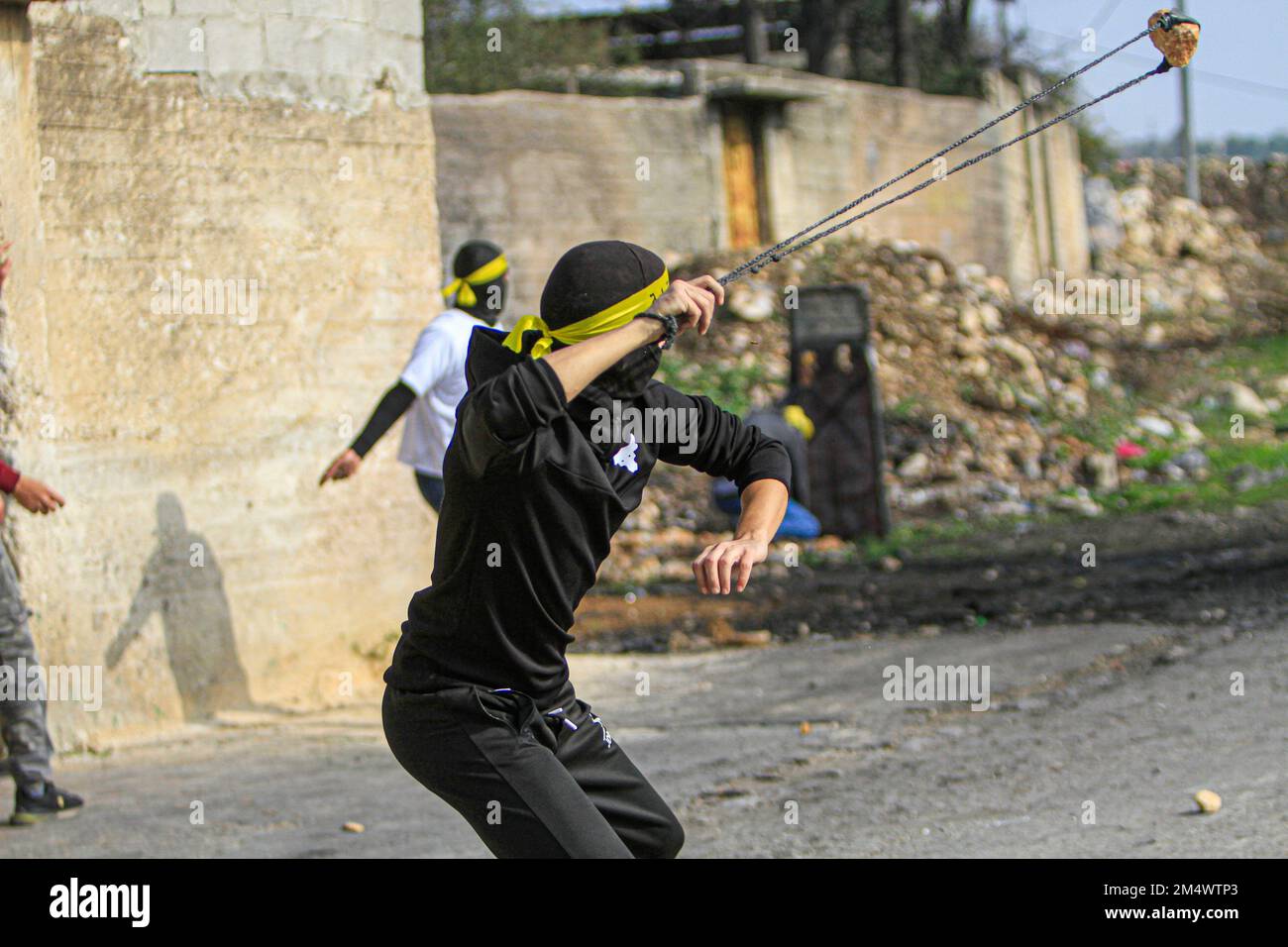 Naplouse, Palestine. 23rd décembre 2022. Un manifestant palestinien masqué lance des pierres sur les soldats israéliens, lors de la manifestation contre les colonies israéliennes dans le village de Kafr Qaddoum, près de la ville de Naplouse en Cisjordanie. Crédit : SOPA Images Limited/Alamy Live News Banque D'Images