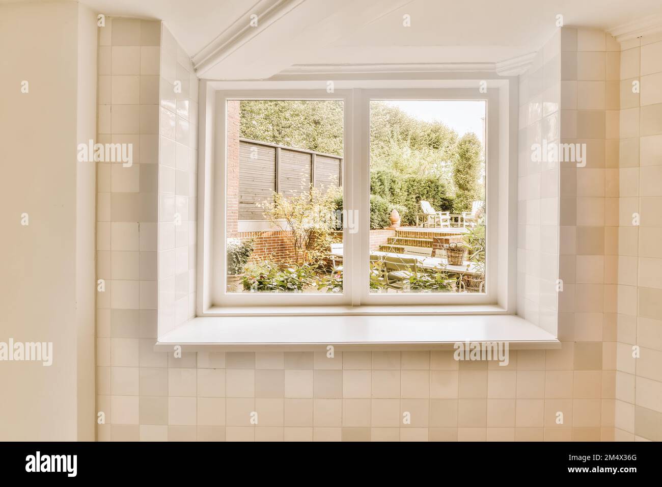 une fenêtre de salle de bains avec vue sur le jardin depuis sa baignoire en face de la maison Banque D'Images