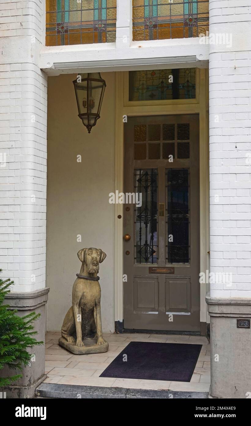 Un chien en pierre qui garde la porte de la maison sans être dérangé. Vu à Zutphen, pays-Bas Banque D'Images