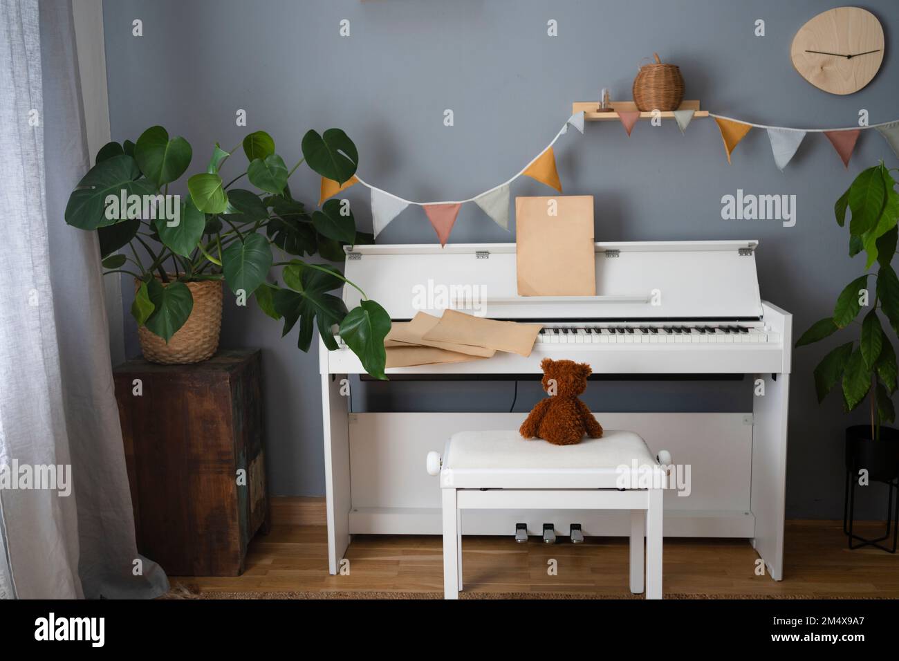 Ours en peluche assis près du piano à la maison Banque D'Images