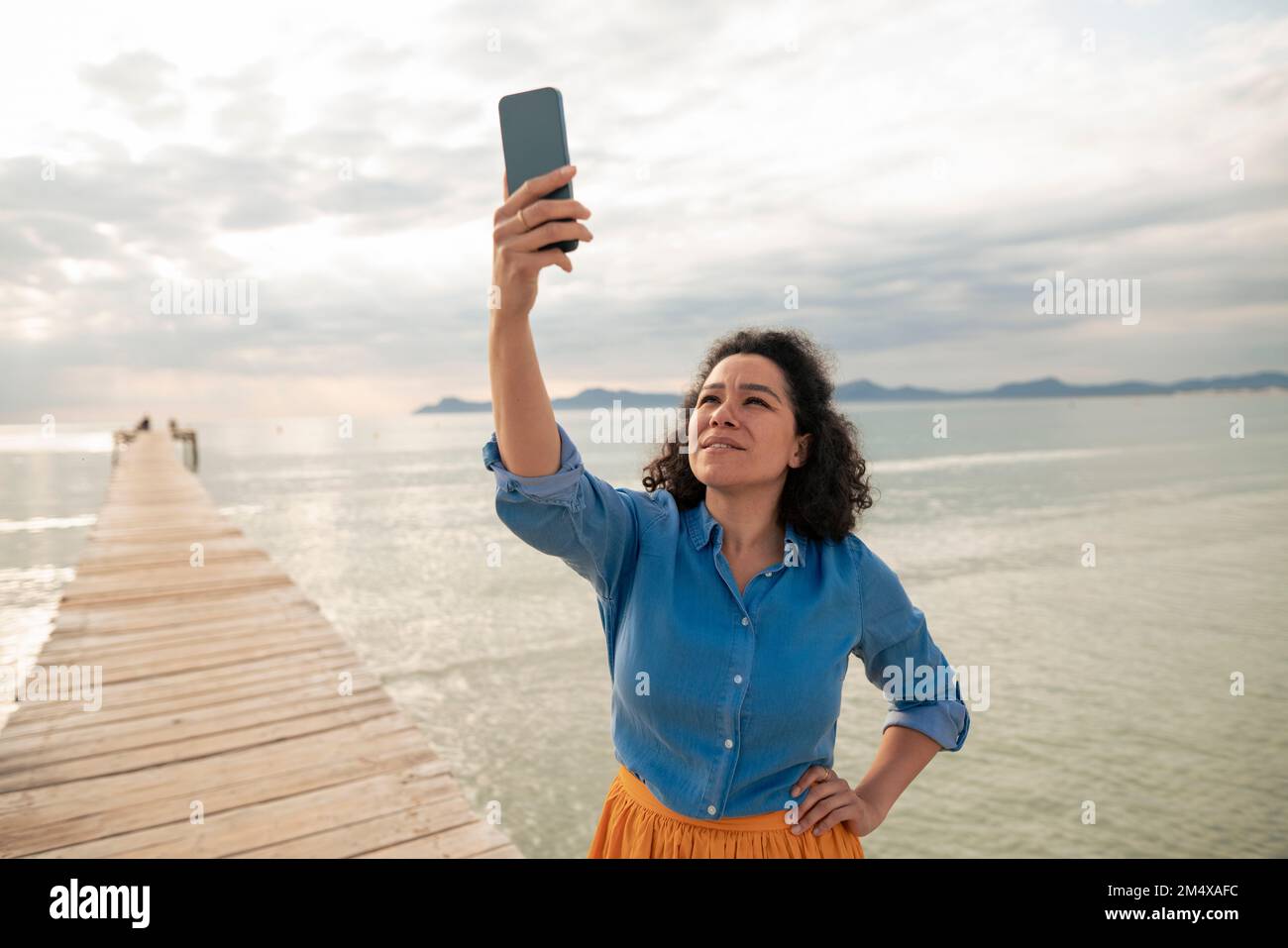 Femme recherchant un réseau de téléphonie mobile sur la jetée Banque D'Images