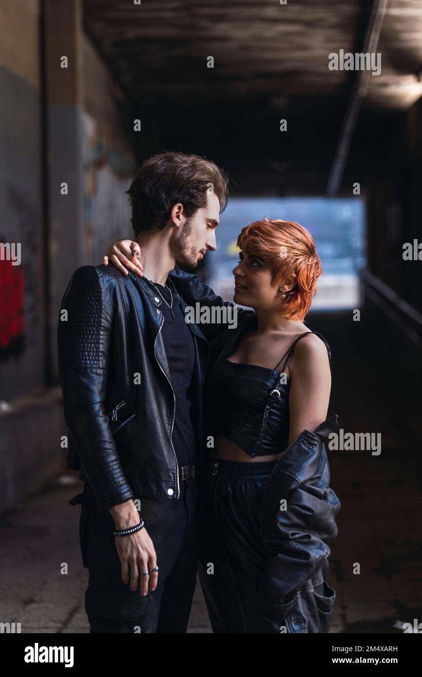 Jeune couple romantique debout ensemble dans le passage souterrain Banque D'Images