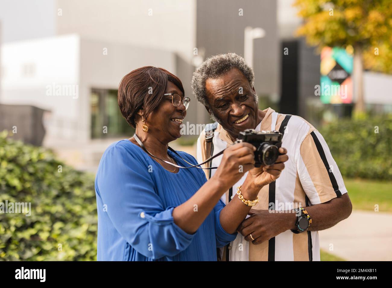 Couple heureux regardant la caméra debout dans le parc Banque D'Images
