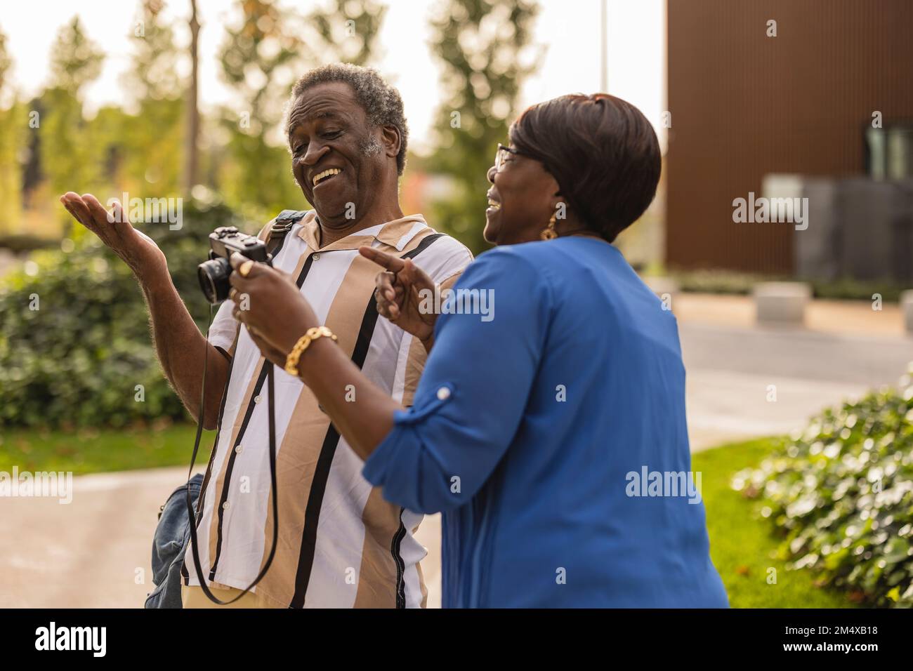 Un couple senior heureux qui se présente avec un appareil photo au parc Banque D'Images