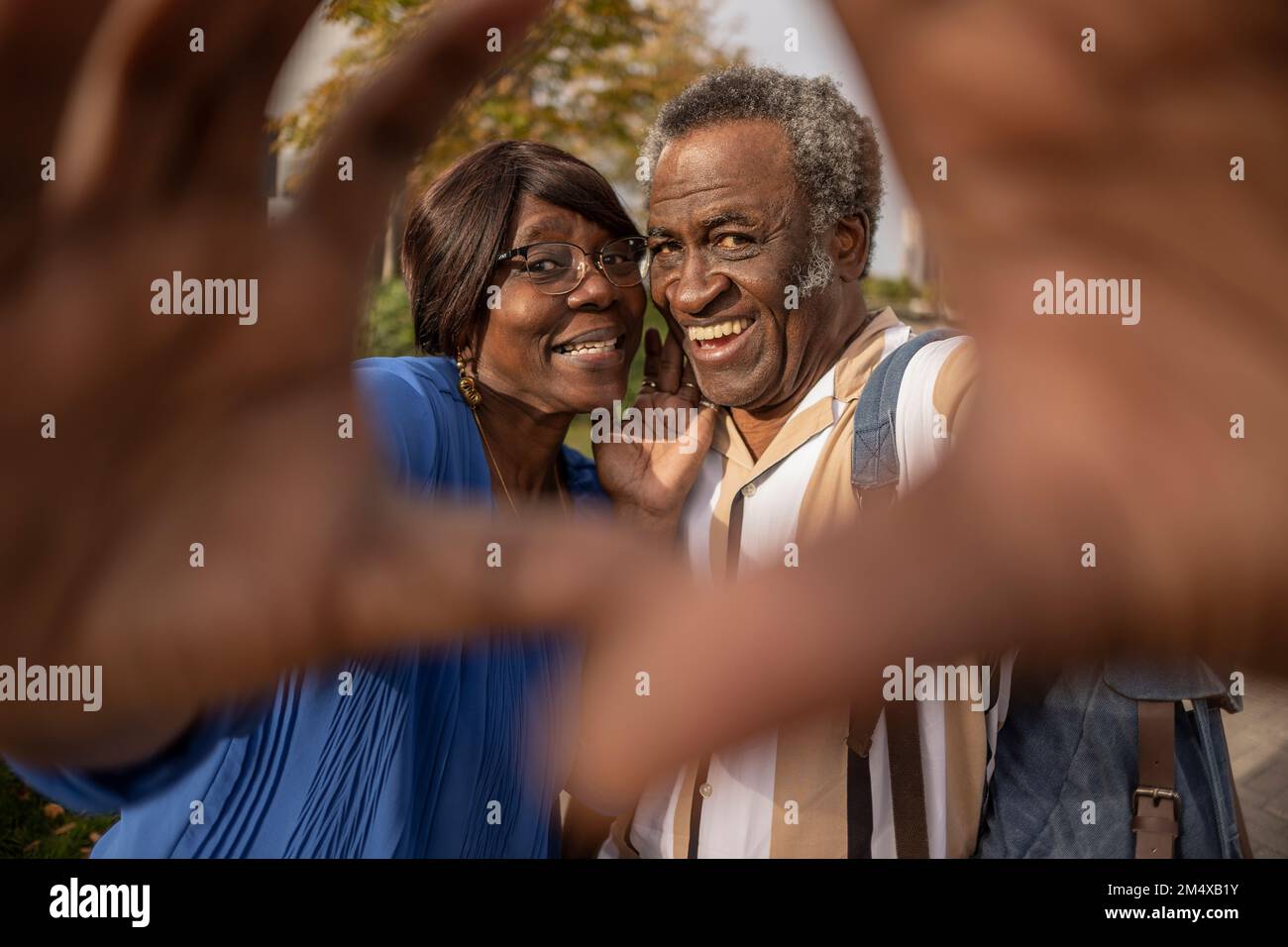 Couple senior heureux en faisant des gestes au parc Banque D'Images