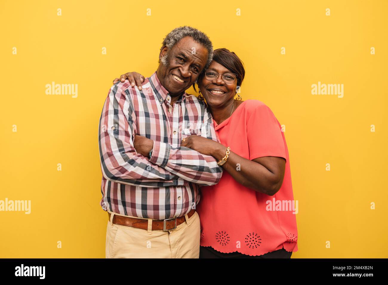 Heureux couple senior debout ensemble sur fond jaune Banque D'Images