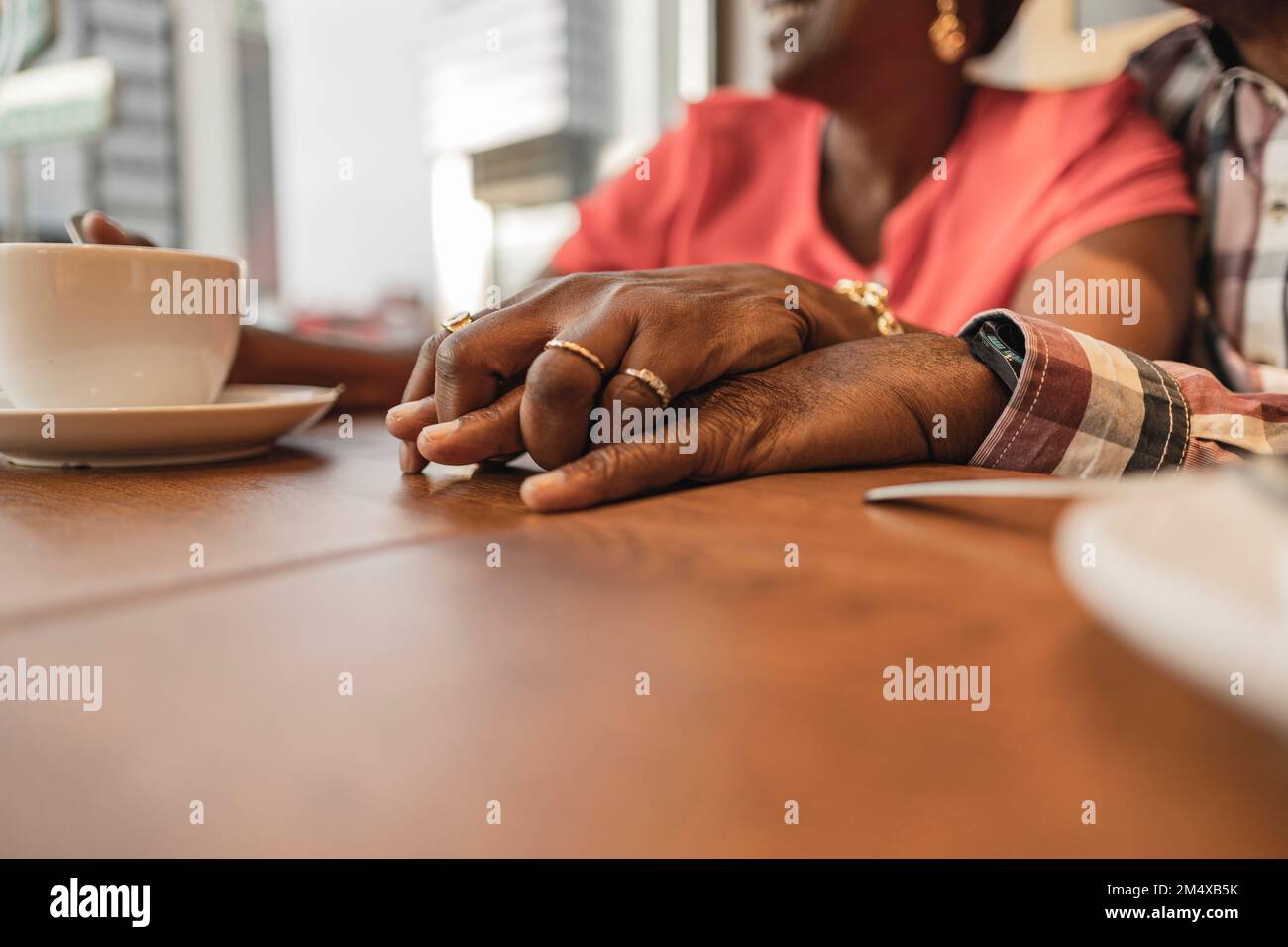 Couple senior tenant les mains à la table dans le café Banque D'Images