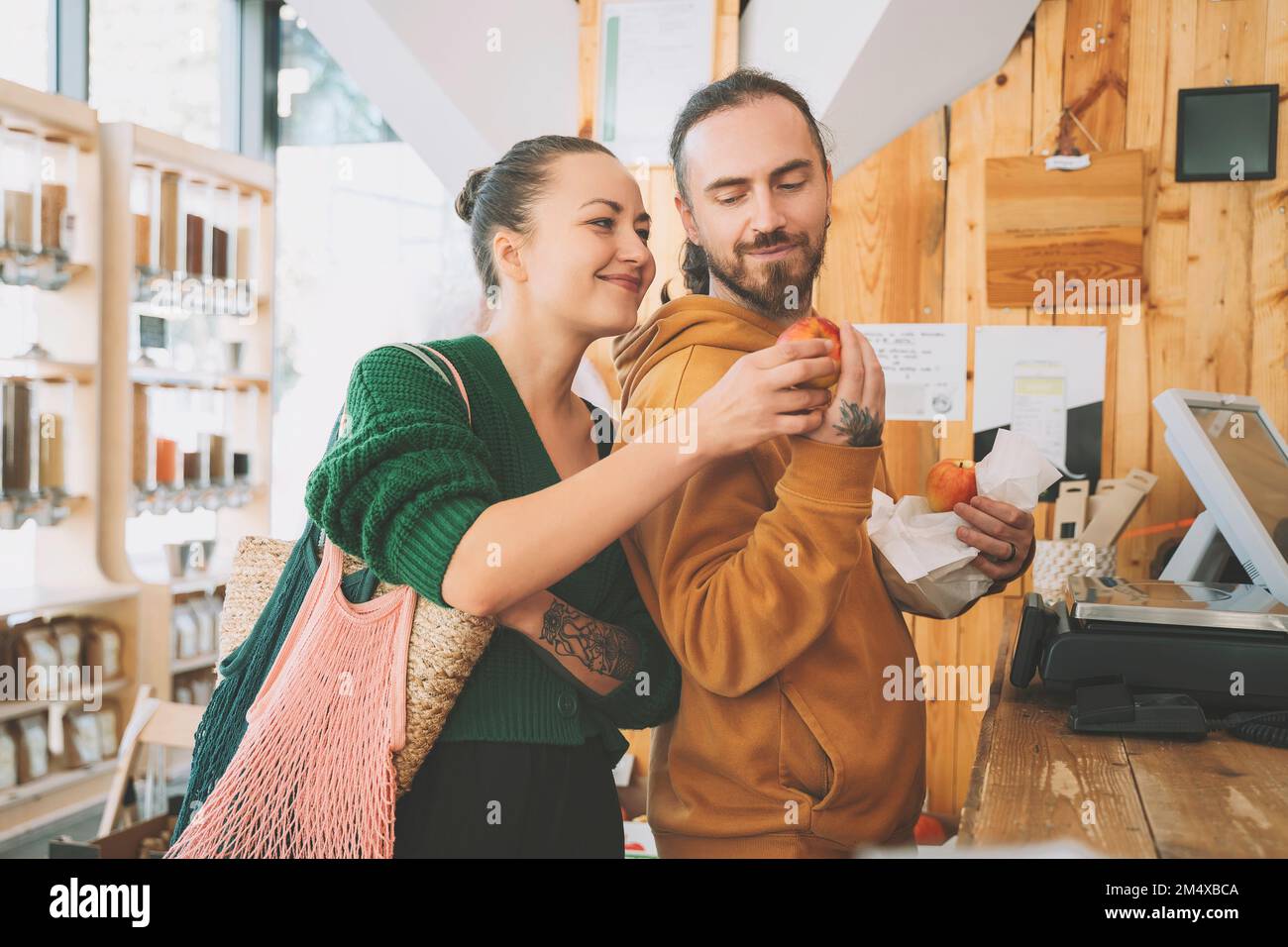 Couple regardant la pomme près du comptoir de caisse dans la boutique Banque D'Images